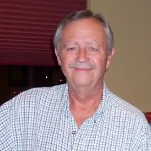 a man with a moustache standing in a living room