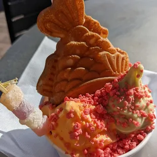 Beautiful and tasty! Pumpkin spice and jasmine green tea ice creams with strawberry crunch and mochi topped with a red bean filled cone.