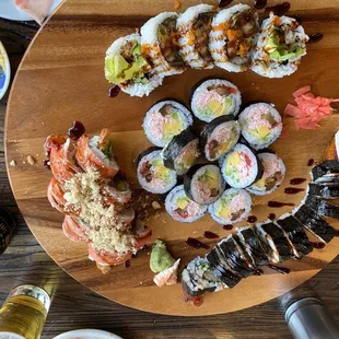 a variety of sushi on a wooden plate