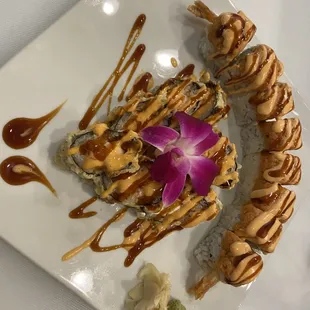 a plate of sushi with a flower