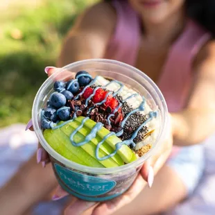 a woman holding a bowl of fruit