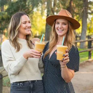 two women holding drinks