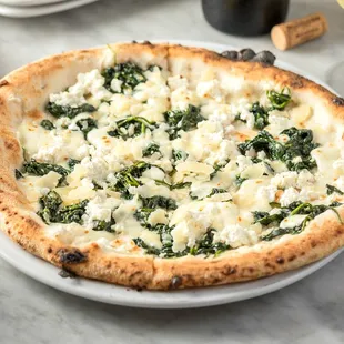 a pizza with spinach and cheese