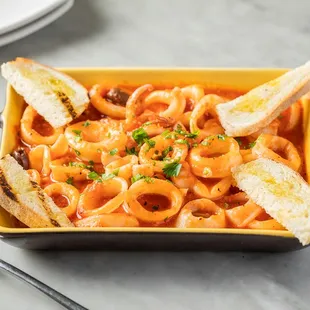 a bowl of pasta with bread