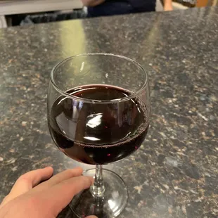 a hand holding a glass of wine