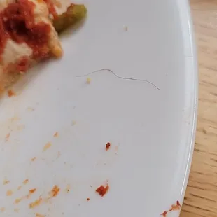 In all fairness, can&apos;t tell if it&apos;s a pubic hair, or a head topping... regardless, it was a hair bake into the pizza.