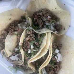 three tacos in a styrofoam container