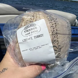a hand holding a bag of cheese turkey
