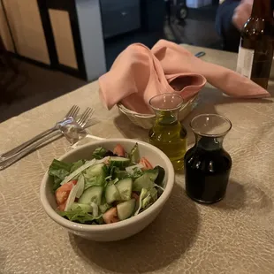 a bowl of salad and a bottle of wine