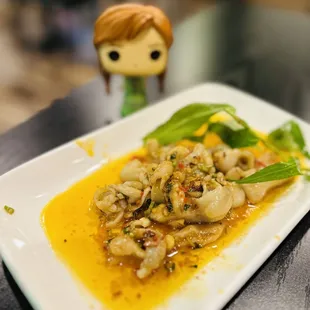 a plate of food with a doll in the background