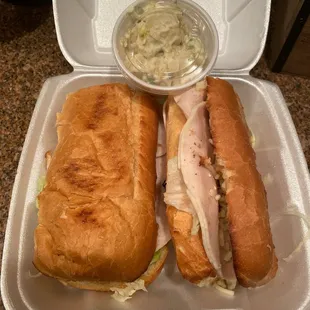 two sandwiches in a styrofoam container