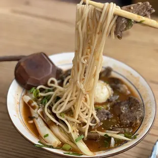 a bowl of noodles with meat and vegetables