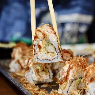 a close up of a sushi with chopsticks
