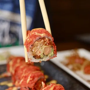 a sushi roll being held by chopsticks