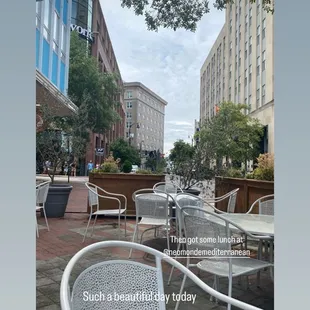 a view of a street with tables and chairs