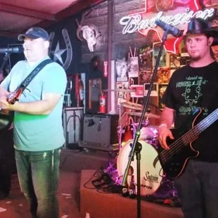 two men playing guitar and singing