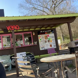the outside of a restaurant with tables and chairs