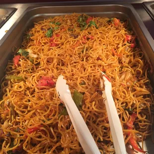 a pan of noodles and chopsticks