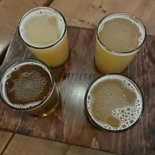 four glasses of beer on a wooden board