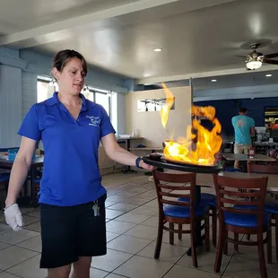 a woman holding a frying pan on fire