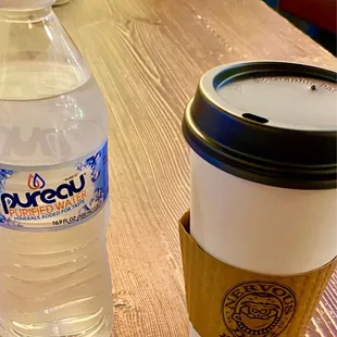 a coffee cup and a bottle of pureau