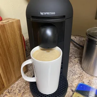 a coffee maker and a cup of coffee