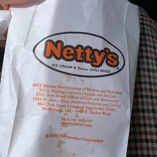 a hand holding a bag of hot dogs