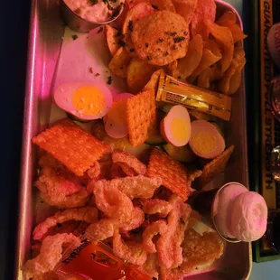 Pickled eggs, pork rinds, and chips with dip