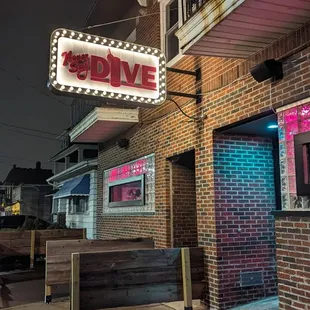 a brick building with a neon sign