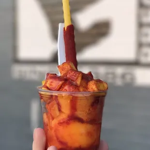 a hand holding a cup of food