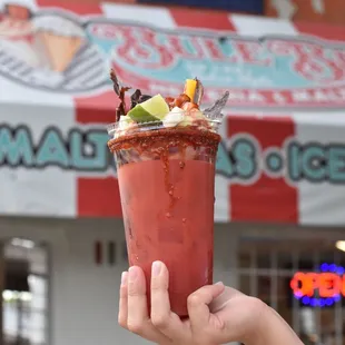 a hand holding a bloody drink