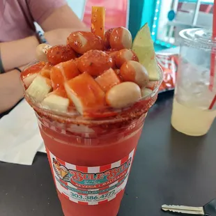 Clamato Preparado. TOP: Cucumber, jicama, Japanese peanuts, chamoy, tajin. Cup: spicy clamato.