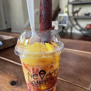 a plastic cup with a straw and a spoon sticking out of it