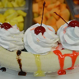 a banana split with whipped cream and cherries