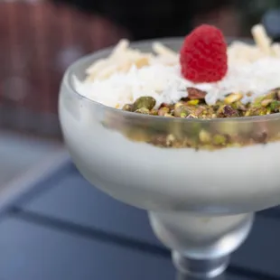 Rose water milk pudding with almond slices, coconut shreds, and crumbled pistachio - a delightful encore to a delicious dinner!