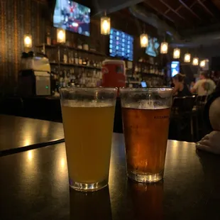 two glasses of beer on a bar