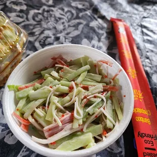 a bowl of coleslaw and a hot dog