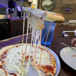 a slice of pizza being lifted by a spatula