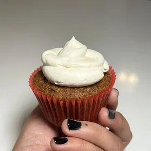 a hand holding a cupcake