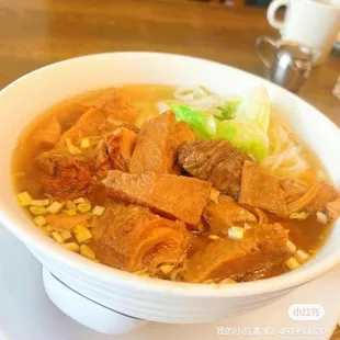 a bowl of soup with meat and noodles