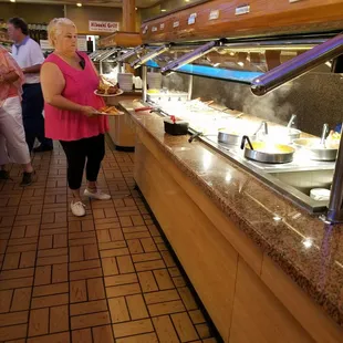a woman serving food to a group of people