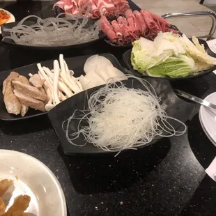 Hot pot ingredients - mushrooms, cabbage, radishes, noodles, meat, and more!
