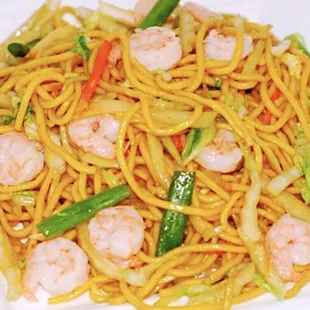 a plate of noodles with shrimp and vegetables
