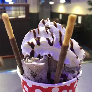 a cup of ice cream with sticks sticking out of it