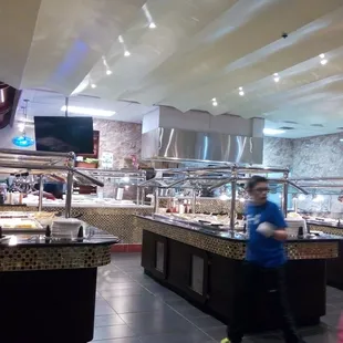 a buffet area with people waiting for food