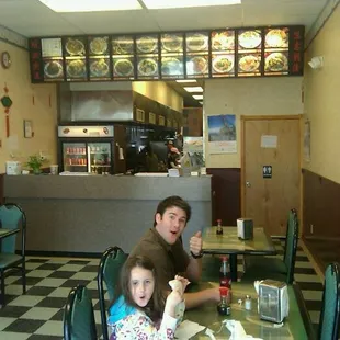 a man and a little girl sitting at a table in a restaurant