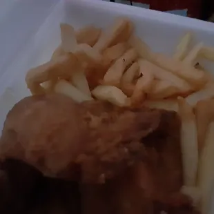 chicken and french fries in a styrofoam container