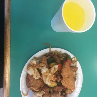 a plate of food and a cup of orange juice