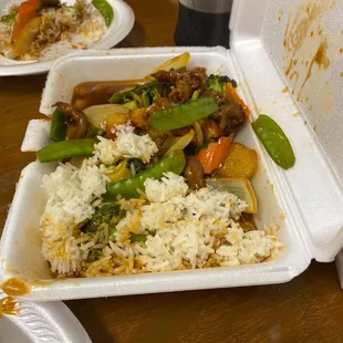 a takeout container of rice and vegetables