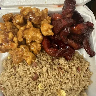 a styrofoam takeout container with rice, meat, and beans
